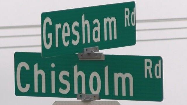 Cars pass by stopped bus on Chisholm Rd in the Shoals